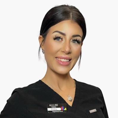 A woman wearing a black scrub top and a name badge that reads "Kristina, Registered Nurse," is smiling at the camera.